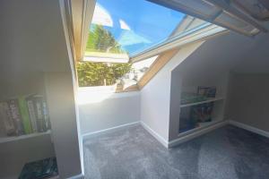 an attic room with a skylight and a book shelf at Spacious 2 Bed APT sleeps 4 near Bournemouth Beach in Bournemouth