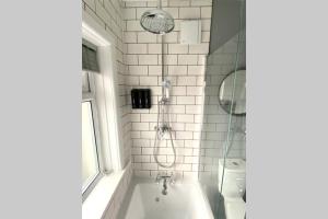 uma casa de banho com um chuveiro, uma banheira e um WC. em Spacious 2 Bed APT sleeps 4 near Bournemouth Beach em Bournemouth