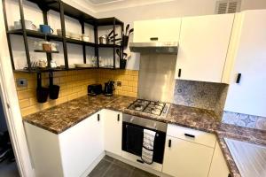 a kitchen with white cabinets and granite counter tops at Spacious 2 Bed APT sleeps 4 near Bournemouth Beach in Bournemouth +11 photos