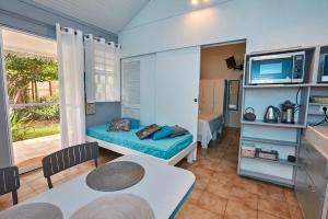 a small room with a couch and a tv at SOLEIL COUCHANT - Gîtes in Deshaies