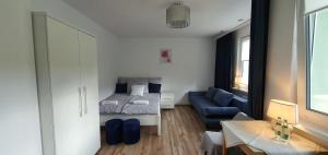 - une petite chambre avec un lit et un canapé bleu dans l'établissement Apartament Altheide, à Polanica-Zdrój