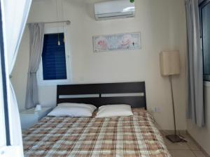 ein Schlafzimmer mit einem Bett mit einer Decke und einem Fenster in der Unterkunft Efterpis12 St. House in Paralimni