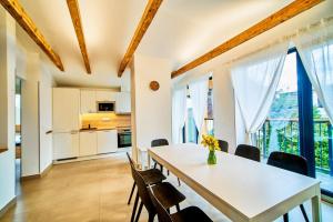 Dolcevita apartments 2 في هاراشوف: مطبخ وغرفة طعام مع طاولة وكراسي بيضاء