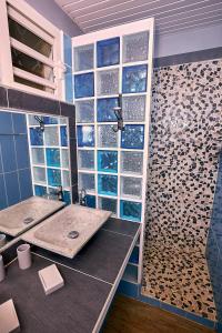 a bathroom with two sinks and a shower at SOLEIL COUCHANT - Gîtes in Deshaies