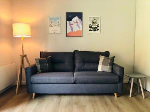 Sofá azul en la sala de estar con lámpara en Le Chalet d'Aurouze 103, Appartement 6 personnes - la Joue du Loup, en La Joue du Loup