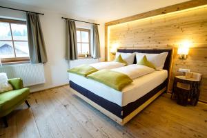a bedroom with a large bed with a wooden wall at Adelheid Keusche - DAS Chalet in Rennweg am Katschberg in Rennweg