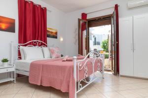 een slaapkamer met een roze bed en een rood gordijn bij NAXOS DIAMOND Studios Apartments in Naxos Chora