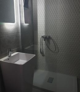 a bathroom with a white sink and a shower at Family Vila Oravita in Oraviţa