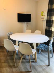 einen Konferenzraum mit einem weißen Tisch und Stühlen in der Unterkunft Le Chalet d'Aurouze 103, Appartement 6 personnes - la Joue du Loup in La Joue du Loup