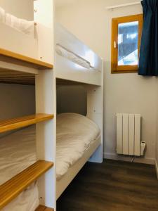 ein Zimmer mit zwei Etagenbetten und einem Fenster in der Unterkunft Le Chalet d'Aurouze 103, Appartement 6 personnes - la Joue du Loup in La Joue du Loup