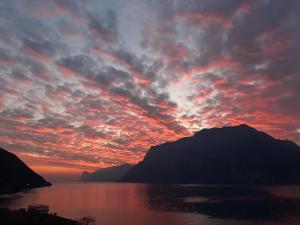 a sunset over a body of water with a mountain at VistaLago Torbole in Nago-Torbole