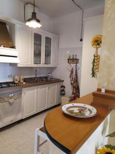 a kitchen with white cabinets and a wooden table at Rosanera&Linus in Manduria
