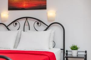 ナクソス・コラにあるNAXOS DIAMOND Studios Apartmentsのベッドルーム1室(赤と白のベッド1台、ランプ2つ付)