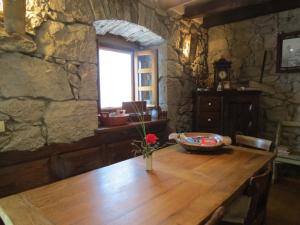 einen Holztisch in einem Steinzimmer mit einer Blumenvase darauf in der Unterkunft Poolhouse Roc (3458) in Roč
