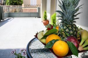 a tray of fruit on a table with a pineapple at Iris's apartment central with parking in Argostoli
