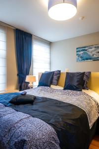 a bedroom with a large bed with blue sheets at Adamas B&B in Dendermonde