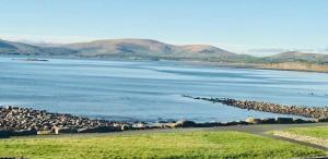 a large body of water with mountains in the background at Seaclusion Luxury Guest Accommodation in Waterville