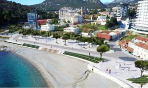 een stad met een strand en gebouwen en de oceaan bij Apartments Beba Zalad in Sutomore