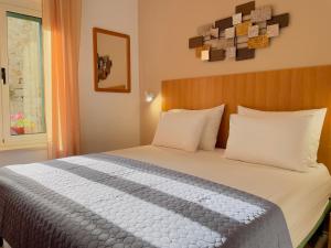 um quarto com uma cama grande e almofadas brancas em Rooms and Apartments Villa Town Gate Hvar em Hvar
