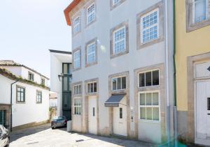 un edificio blanco con ventanas en una calle en Oporto Comfort Dom Hugo - Historic Apartments, en Oporto