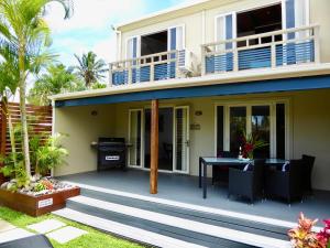 a patio with a table and a house at Muri Beachside Villa with pool in Rarotonga