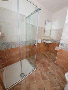 y baño con ducha y puerta de cristal. en Villa Caterina Posada, en Posada