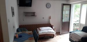 オストロボにあるHalebajaのソファ、ベッド、時計が備わる客室です。