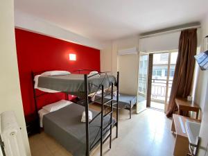 雅典的住宿－阿提米希恩酒店，一间设有三张双层床和红色墙壁的客房