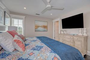 a bedroom with a bed and a flat screen tv at Casa Amiga by Beach Retreats in Anna Maria