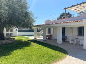 uma casa com um pátio com uma mesa e cadeiras em Villa Falconara em Noto Marina