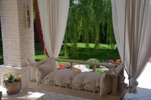 a porch with a bed and a window with flowers at Asso Bed & Breakfast in Manerba del Garda
