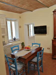ein Esszimmer mit einem Holztisch und blauen Stühlen in der Unterkunft La casa a Porta a Pago in Torrita di Siena