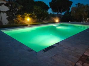 a swimming pool lit up at night at Agriturismo IL CANTINIERE in Grosseto