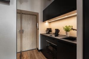 een keuken met een zwart aanrecht en een wastafel bij Morning Light Sopot Apartment in Sopot