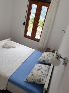 a bedroom with a bed with two pillows and a window at Apartment Marta 2 in Kotor