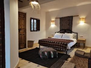 um quarto de hotel com uma cama e uma cadeira em Les Jardins de Taja em Ourika