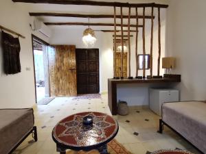 a living room with a table in the middle of a room at Les Jardins de Taja in Ourika