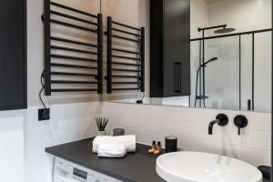 a white bathroom with a sink and a mirror at Morning Light Sopot Apartment in Sopot