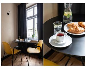 een tafel met een kopje thee en een bord croissants bij Morning Light Sopot Apartment in Sopot