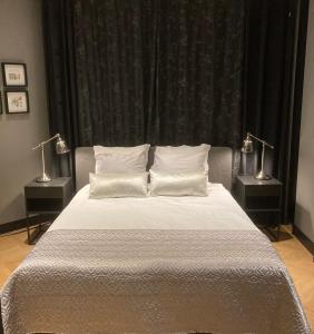 a bedroom with a bed with two lamps on two tables at Hoeve Altena Apartment in Woudrichem