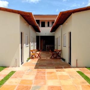 an outdoor patio with tables and chairs in a building at CASA BRANCA - Jijoca de Jericoacoara in Jijoca de Jericoacoara