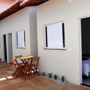 a table and chairs sitting next to a white wall at CASA BRANCA - Jijoca de Jericoacoara in Jijoca de Jericoacoara