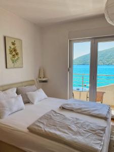 a bedroom with a bed with a view of the ocean at Apartments Bellevue - Otasevic in Herceg-Novi