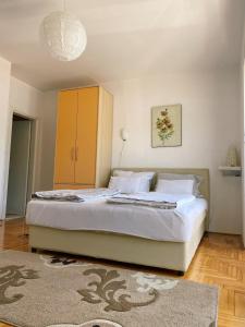 a bedroom with a large bed with a yellow cabinet at Apartments Bellevue - Otasevic in Herceg-Novi