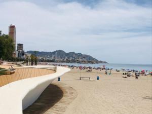 ein Strand mit Menschen im Sand und im Meer in der Unterkunft Ca Àngela in Bolulla