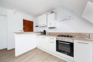 a white kitchen with white cabinets and a sink at Charmant T1 au cœur du centre historique de Dinan in Dinan