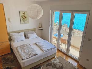 1 dormitorio con 1 cama y vistas al océano en Apartments Bellevue - Otasevic, en Herceg-Novi