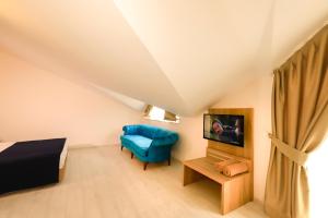 um quarto com uma cama e uma cadeira azul em ERAMAX HOTEL KEMER em Kemer