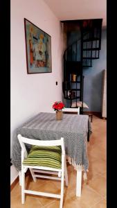 a table with a chair and a table with flowers on it at A casa dell’amica mia in San Nicola Arcella