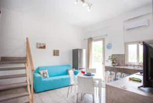 a living room with a blue couch and a kitchen at Casa Gioia in Giardini Naxos